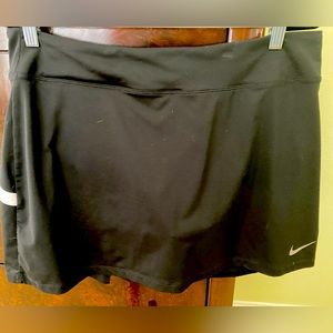 Nike golf skort black with white accent trim on back with pleats. Pullon. Large
